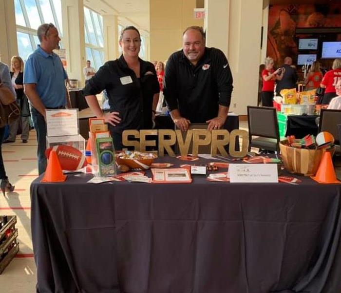 A booth set up with SERVPRO name on the front with people standing behind it